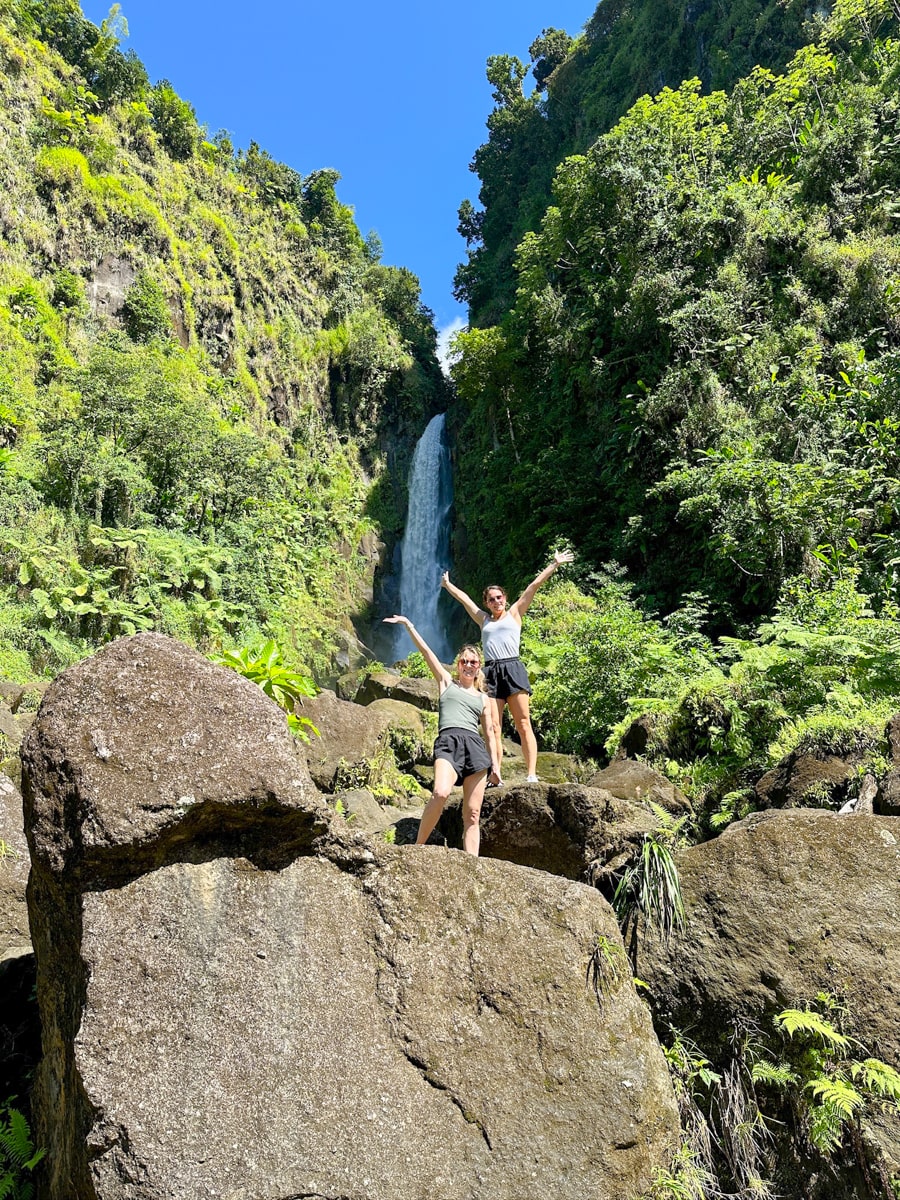 people hiking up river rocks to reach the "father" falls at Trafalgar Falls in Dominica