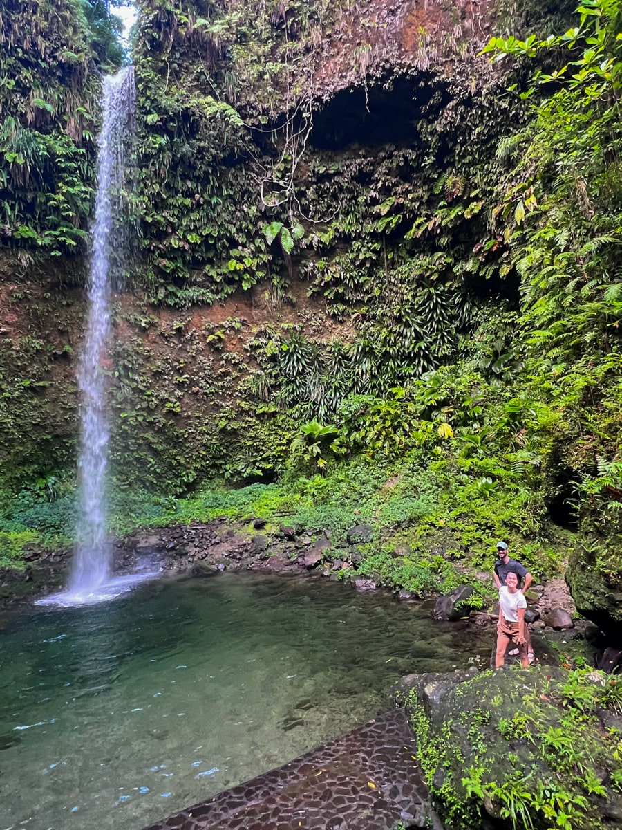 people standing in the swimming hole at the base of Spanny falls in Dominica