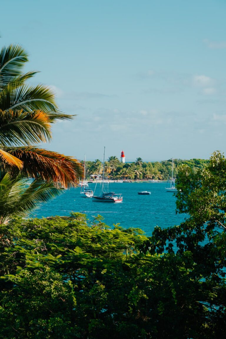 Boats and lighthouse on islet off Guadeloupe Island, Caribbean.