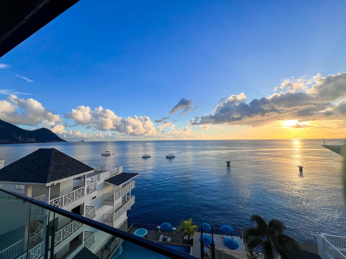 view from a hotel room at Fort Young Hotel overlooking the ocean at sunset