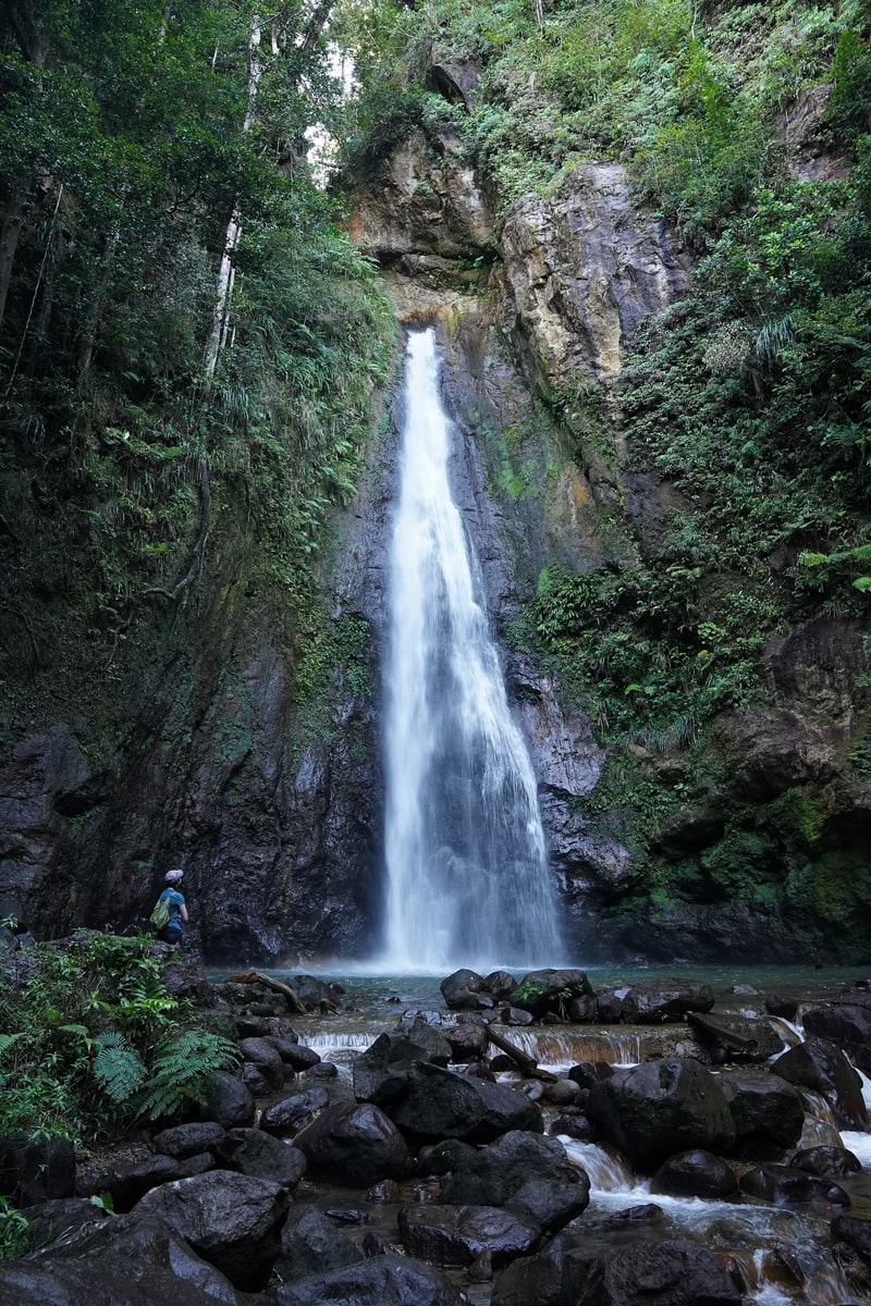 Person standing at the base of Syndicate Falls in Northwest Dominica