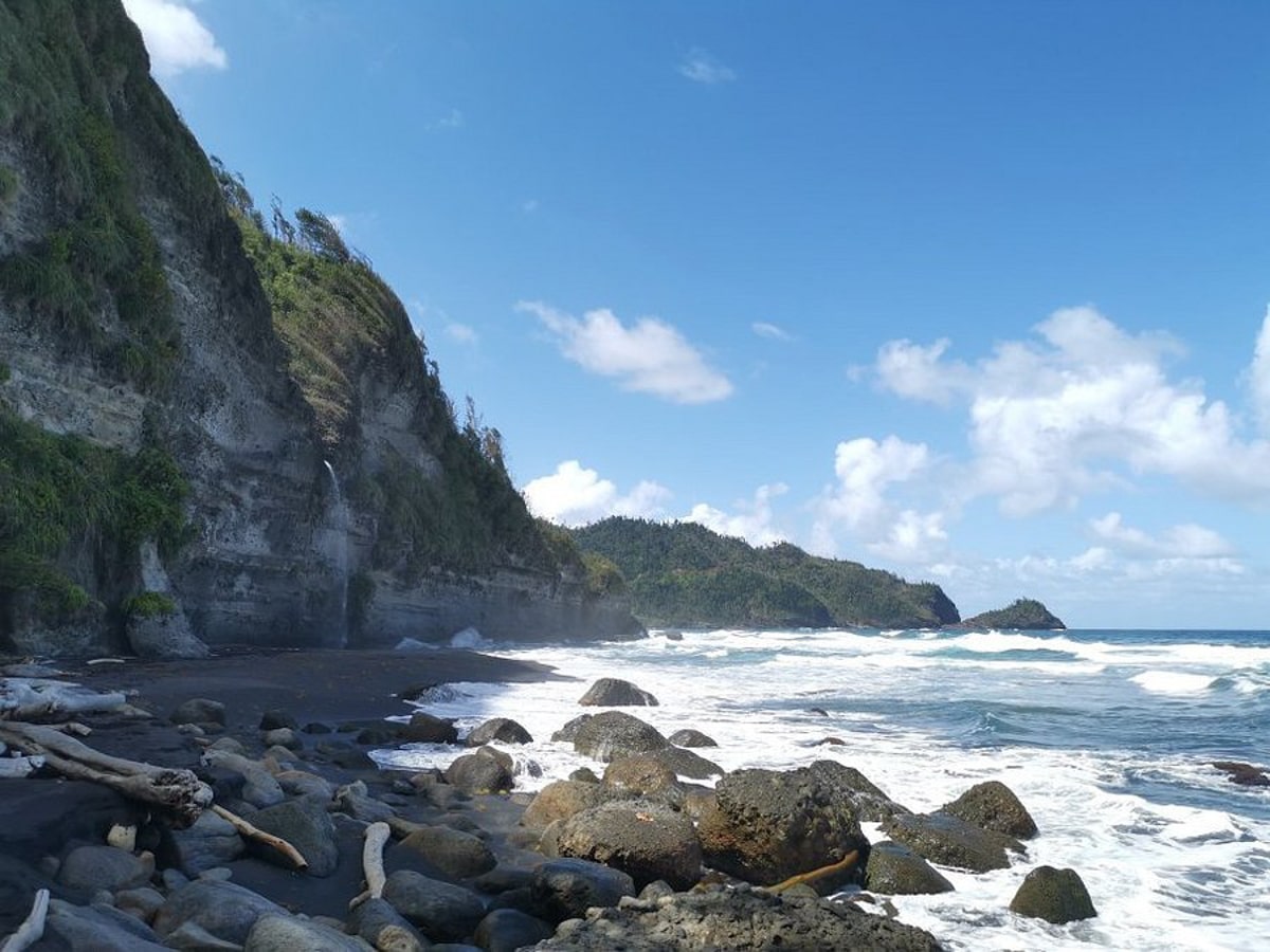 Wavine Cyrique beach in Dominica with waterfall cascading onto the black sand beach