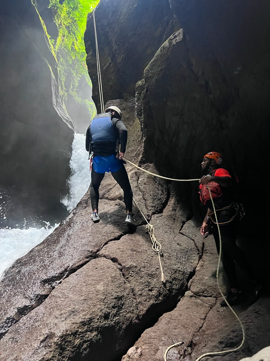 man rappelling down a rock in titou gorge in Dominica