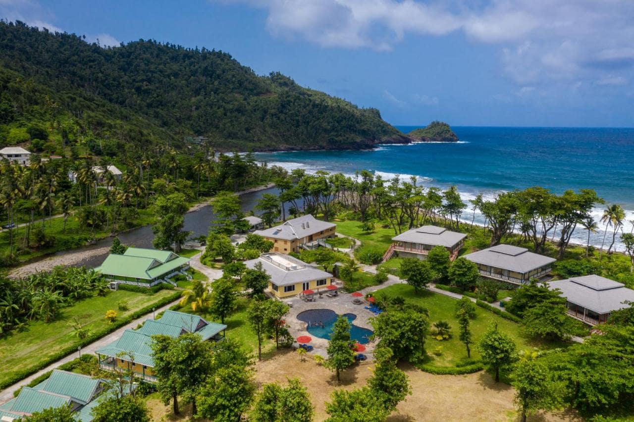 Aerial view of Rosalie Bay eco resort and spa with mountains and blue sea in the background