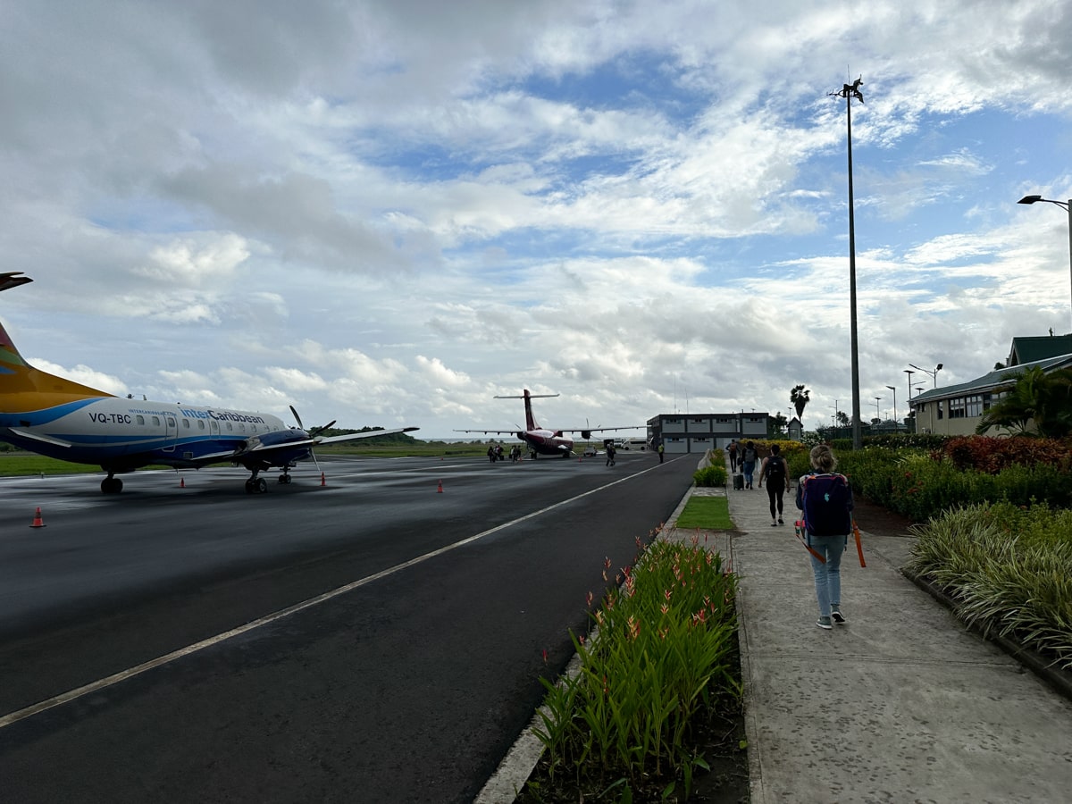 walking on the sidewalk to the airplane at Douglas Charles Airport in Dominica