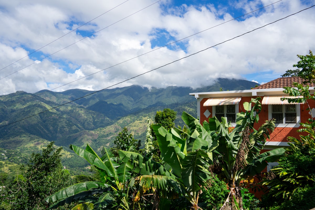 Orange house contrasting with the green foliage and mountains in the Blue Mountains of Jamaica