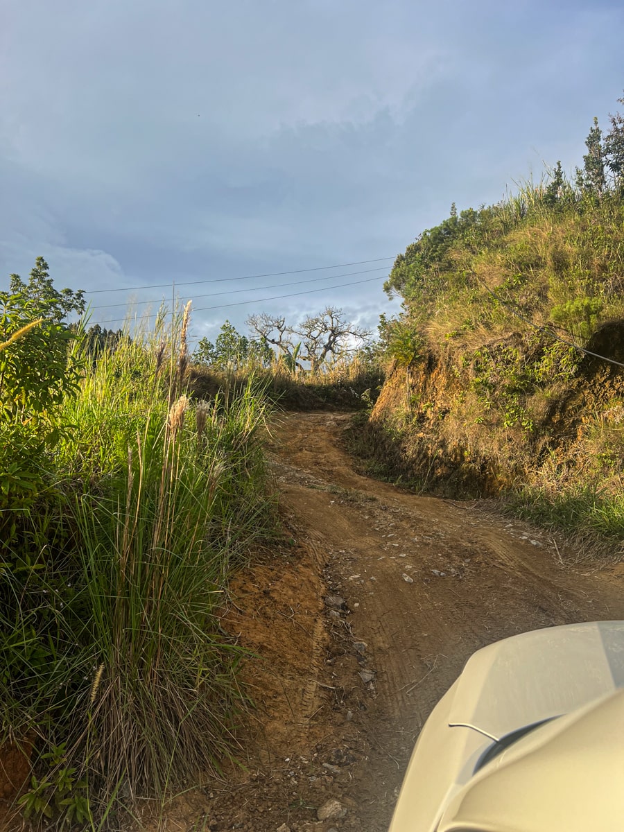 view of a muddy rutted road where many cars get stuck and are unable to pass 