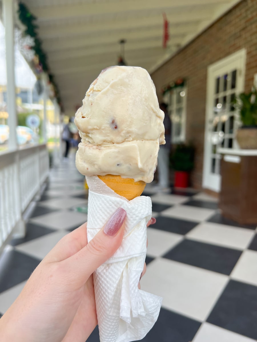 woman holding a cone of butter pecan ice cream at Devon House in Kingston