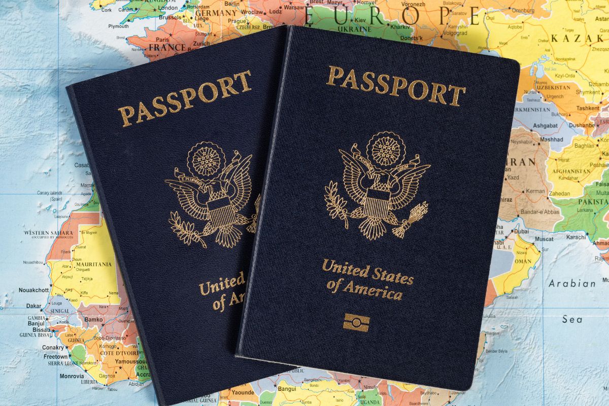 two united states passports sitting on top of a flat world map