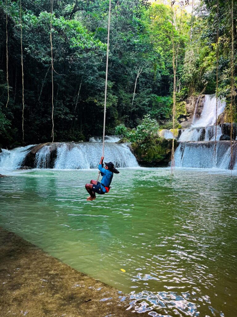 man swinging on a rope over YS falls into a pool over water