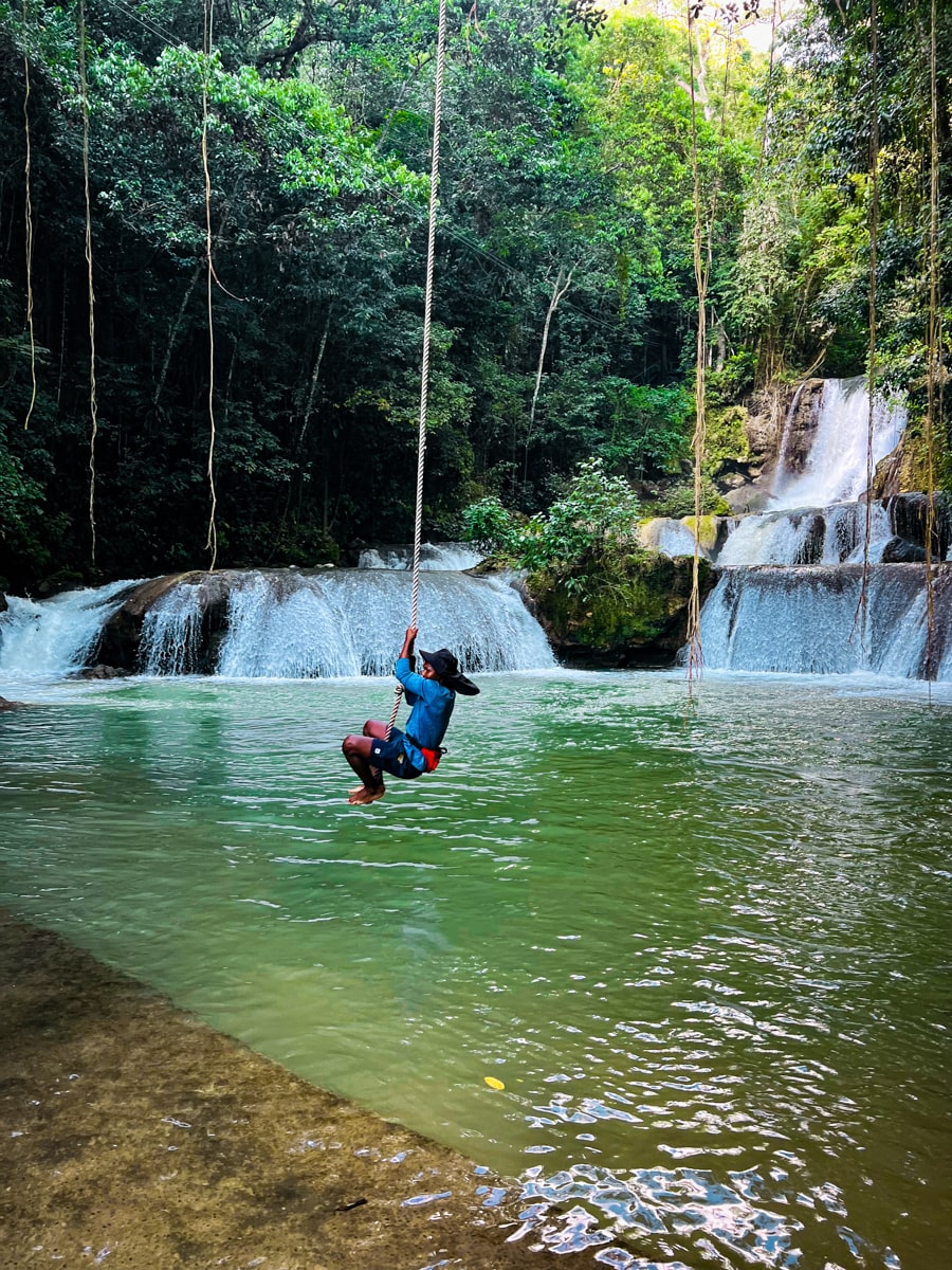 man swinging on a rope over YS falls into a swimming hole 