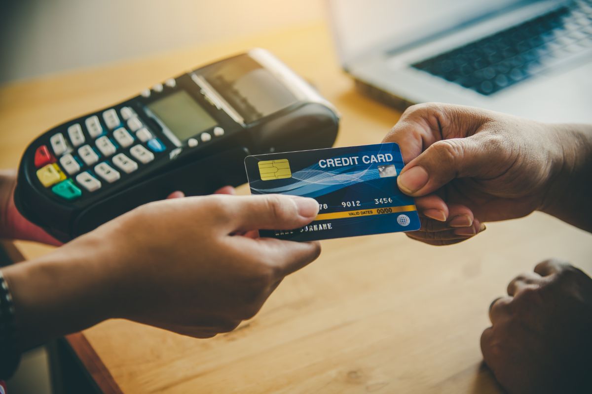 person handing over a credit card to pay for a transaction