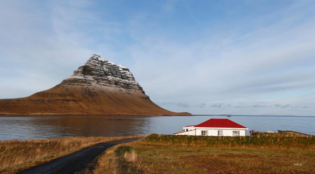 Hellnafell apartment house sitting in front of the Kirkjufell mountain only seperated by a small lake