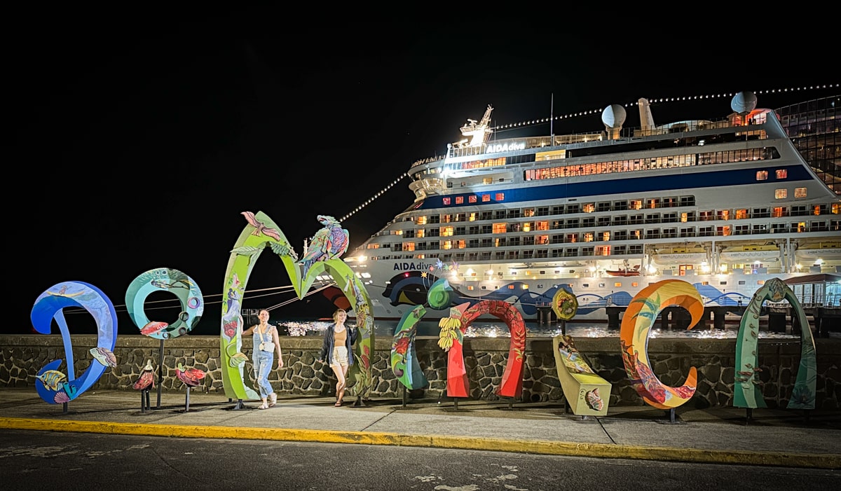 Large letters spelling out Dominica in front of a cruise ship in Roseau Domincia