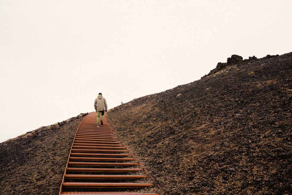 person walking up to the Saxholl crater on the metal staircase on a gloomy day