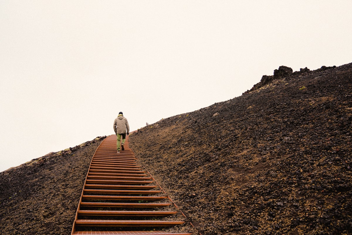 person walking up to the Saxholl crater on the metal staircase on a gloomy day