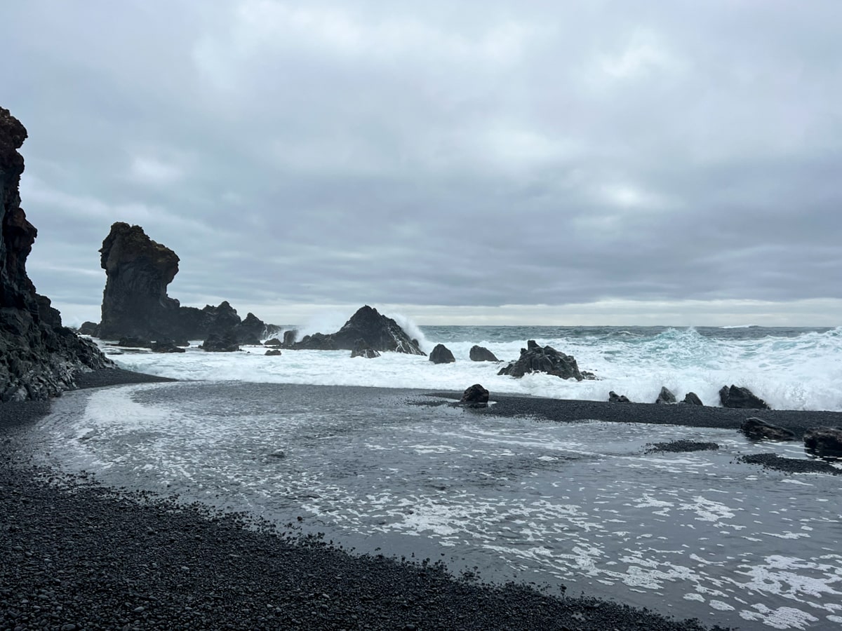 White waves crashing over the black sand beach at Djupalonssandur Beach in the Snaefellsnes Peninsula Iceland