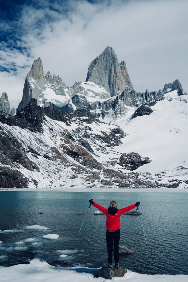 Person celebrating with arms out in front of Fitz Roy in the Patagonia mountains of El Chalten, Argentina